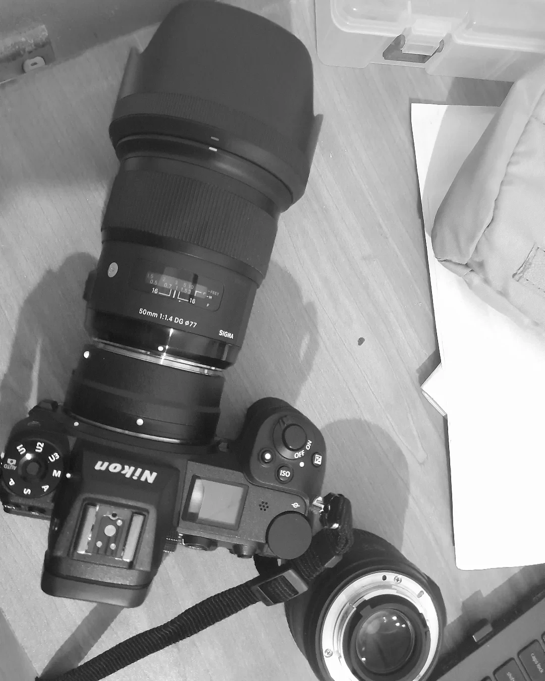 Monochrome close-up of a Nikon camera and long lens